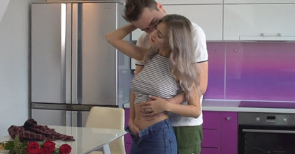 Молодая пара ласкается на кухне